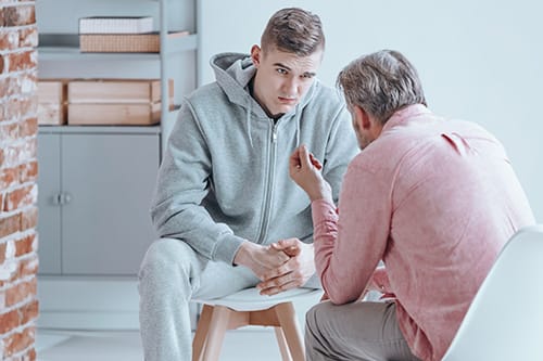 teen male listening intently to a therapist