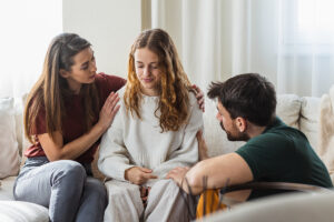 parents comforting child and discussing benefits of family therapy