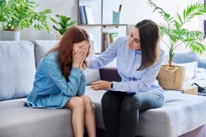 teen receiving comfort from counselor in trauma therapy program