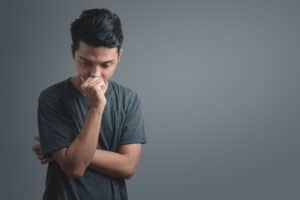 young person thinking against gray backdrop trying to recall tips to help social anxiety