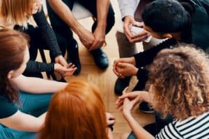 young people huddled in group therapy learning the importance of teen therapy