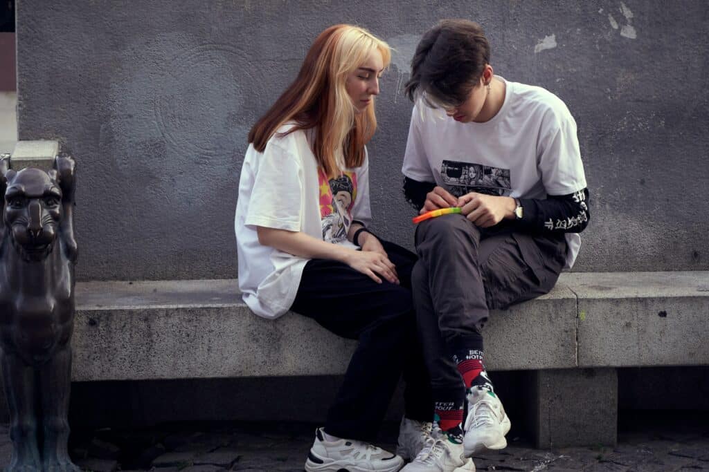 teen boy and girl sitting outside
